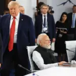 Donald Trump at the G7 Summit, smiling and gesturing.