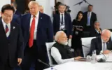 Donald Trump at the G7 Summit, smiling and gesturing.