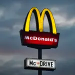 A close-up of a McDonald's Big Mac burger with fries and a drink.