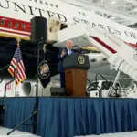 Donald Trump standing next to the Qatar-gifted Air Force One, a luxurious presidential aircraft.