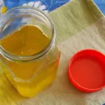 Woman performing a ghee purity test at home using a simple method.