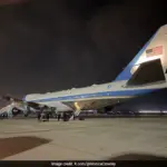 Air Force One aircraft on the tarmac with a Qatari jet in the background.