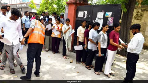 NEET re-exam 2026 security measures in place with students taking the test under camera surveillance.