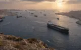 Oil tankers navigating the Strait of Hormuz after its reopening following a ceasefire, with oil prices falling.