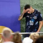 Miguel Almiron receives a red card for covering his mouth during a football match.