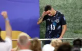 Miguel Almiron receives a red card for covering his mouth during a football match.