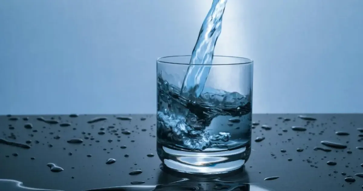 Various fresh ingredients like lemon, cucumber, mint, and berries arranged around a glass of water, symbolizing enhanced hydration.