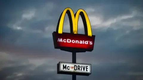A close-up of a McDonald's Big Mac burger with fries and a drink.