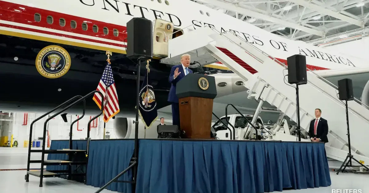 Donald Trump standing next to the Qatar-gifted Air Force One, a luxurious presidential aircraft.