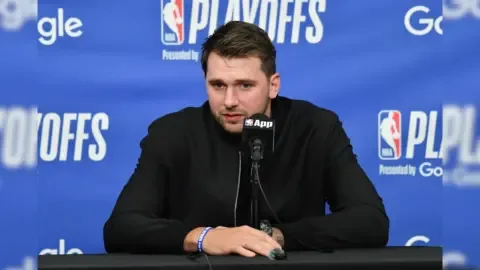 Luka Doncic in a Slovenia national team jersey, looking thoughtful.