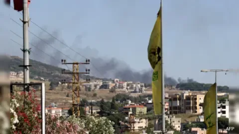 Explosion and smoke rising from a location in Lebanon following Israeli airstrikes, with a subtle background hint of international diplomacy.