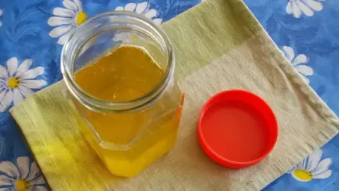 Woman performing a ghee purity test at home using a simple method.