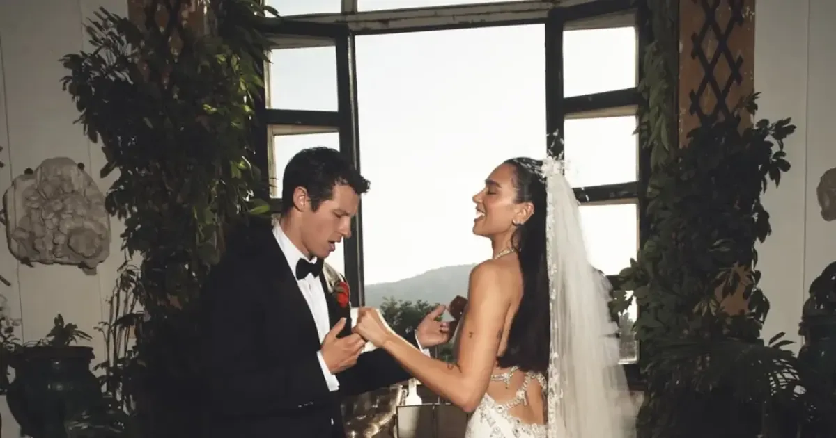 Dua Lipa and Callum Turner smiling at their Italian wedding ceremony.