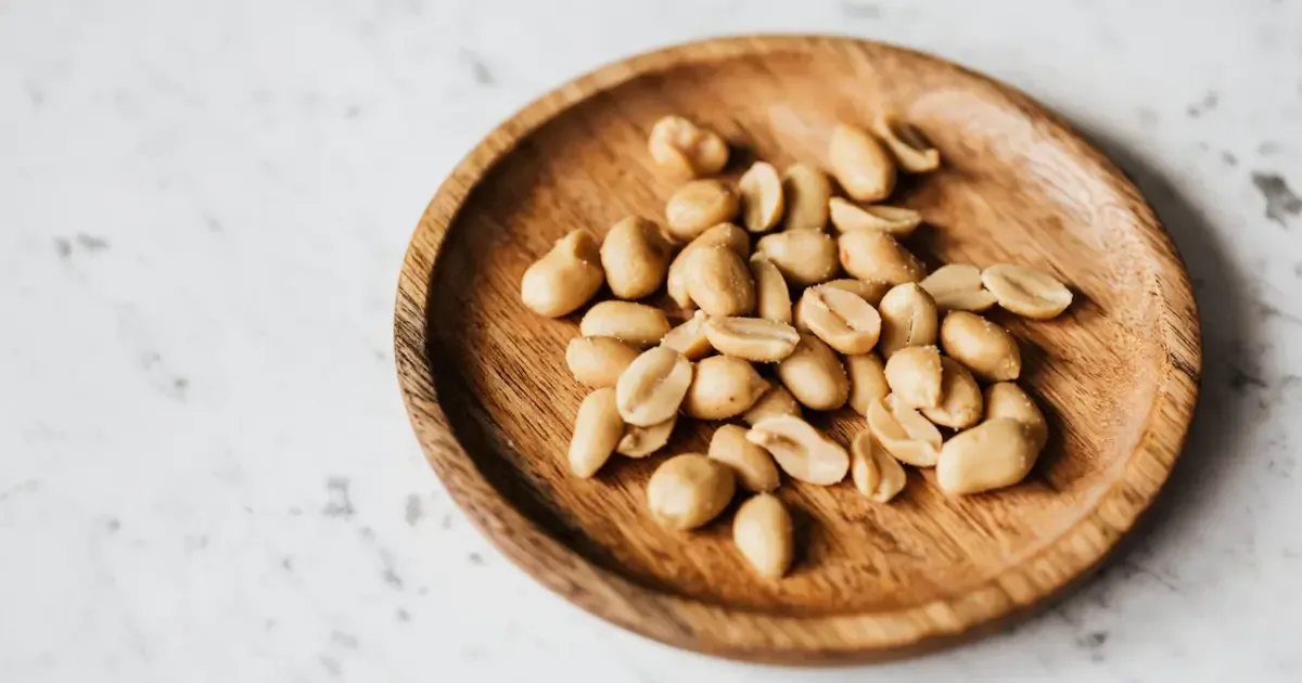 A person carefully placing airtight containers filled with peanuts into a cool, dark pantry.