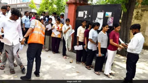 NEET re-exam 2026 security measures in place with students taking the test under camera surveillance.