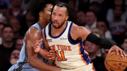 Jalen Brunson embraces Mitch Johnson after a game, highlighting their strong bond.