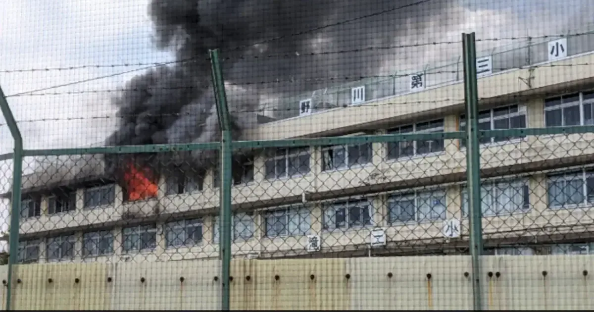 Firefighters battle a blaze at a Tokyo elementary school, with smoke billowing from the building.