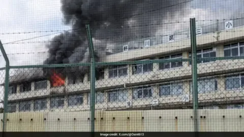 Firefighters battle a blaze at a Tokyo elementary school, with smoke billowing from the building.