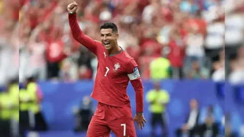 Cristiano Ronaldo celebrating a goal during a World Cup match, highlighting his record-breaking achievement.