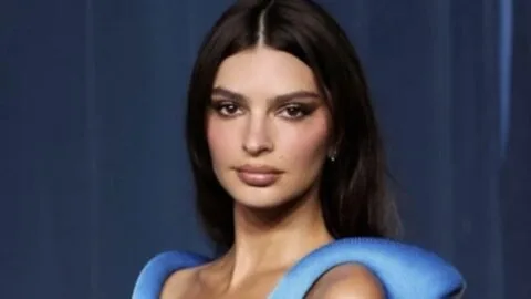 Emily Ratajkowski at an event, looking thoughtful.