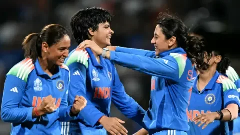 Indian cricketers Shafali Verma and Smriti Mandhana smiling together on the field.