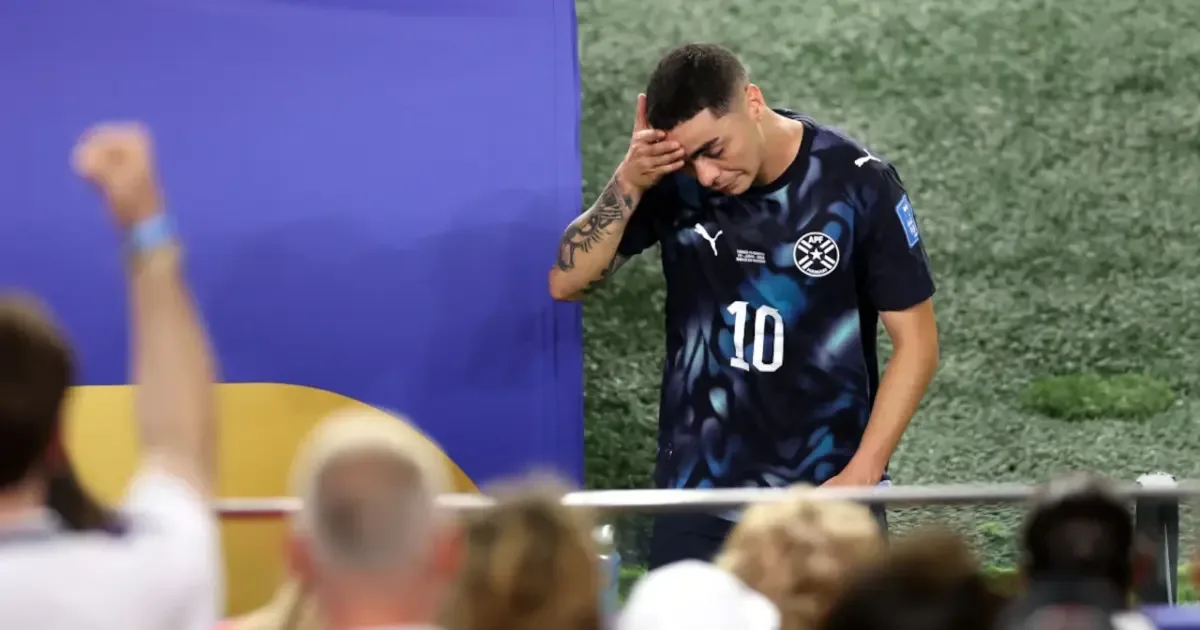 Miguel Almiron receives a red card for covering his mouth during a football match.